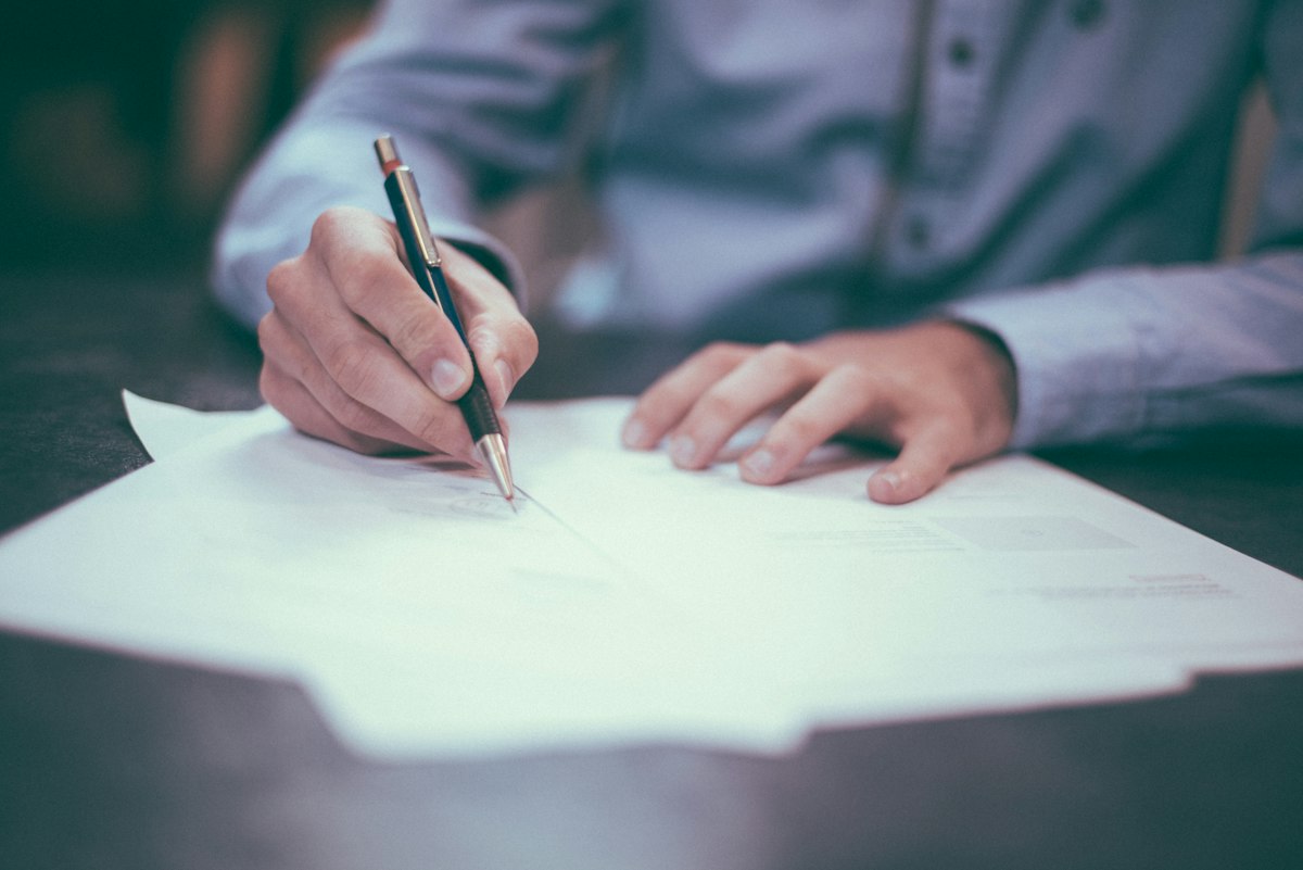 Signing an insurance certificate across a desk